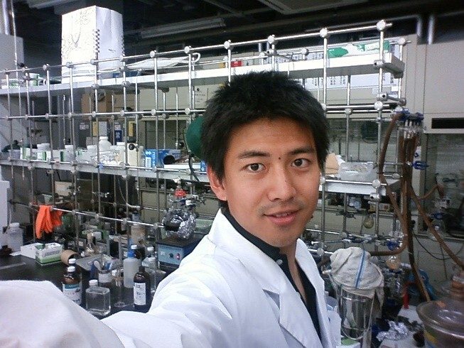 白衣姿で実験室に立つ、研究開発時代の𠮷良佳晃